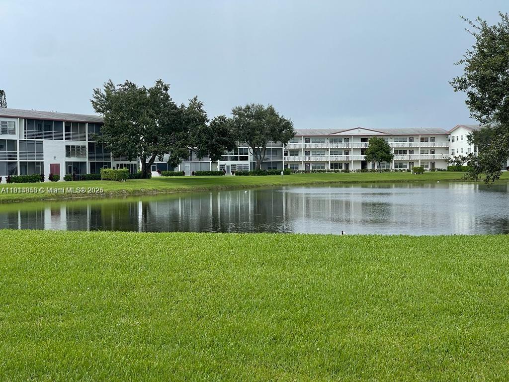 a view of a house with a yard and a pond