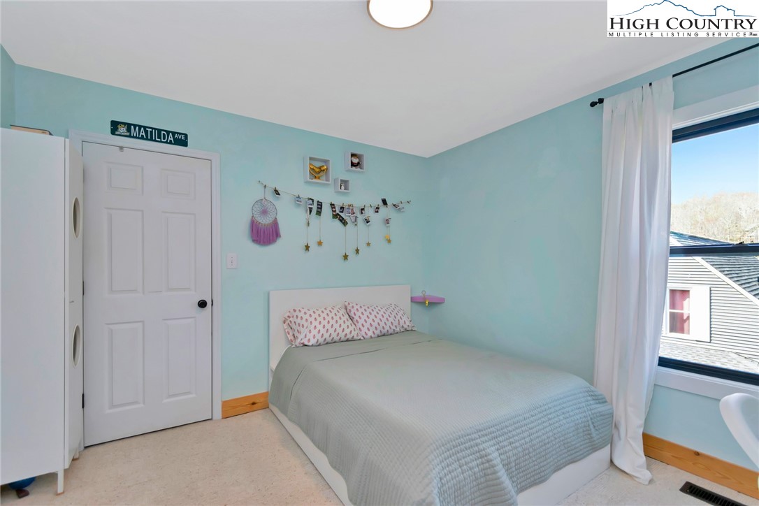 885 Alpine Drive Seven Devils, NC 28604 - Photo 25 of 50 a bedroom with a bed and a window