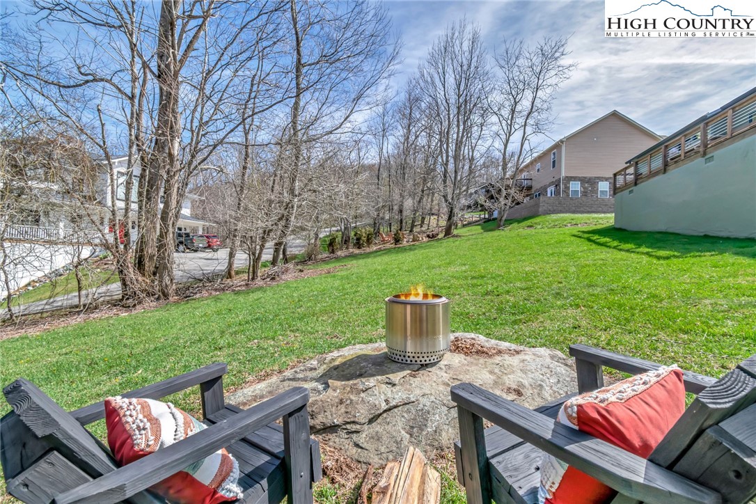 885 Alpine Drive Seven Devils, NC 28604 - Photo 41 of 50 a view of a deck with couches table and chairs and garden