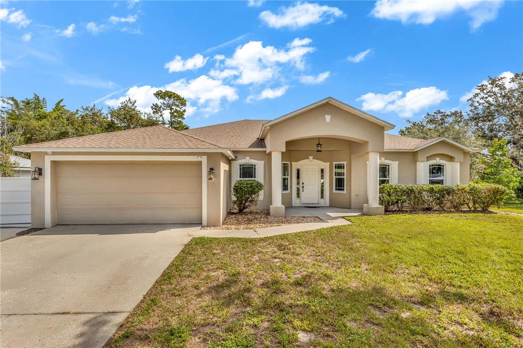 1715 Concert Road Deltona, FL 32738 - Photo 1 of 1 a front view of a house with a yard and garage