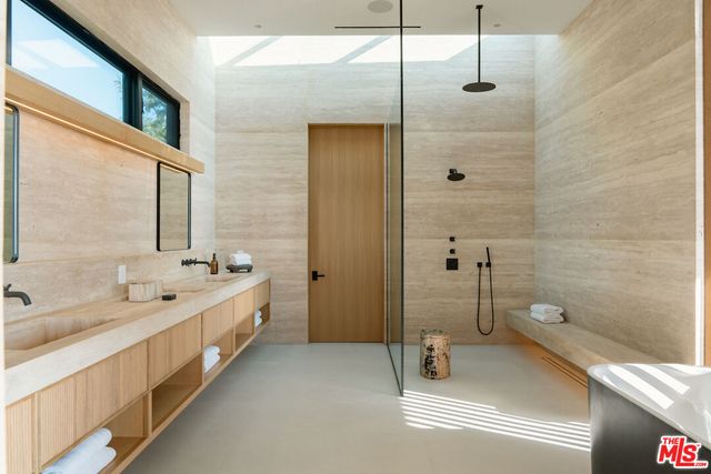 a bathroom with a tub a sink and mirrors