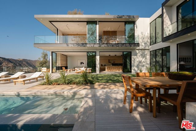 a view of a house with backyard and sitting area