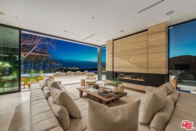 a living room with furniture and a floor to ceiling window
