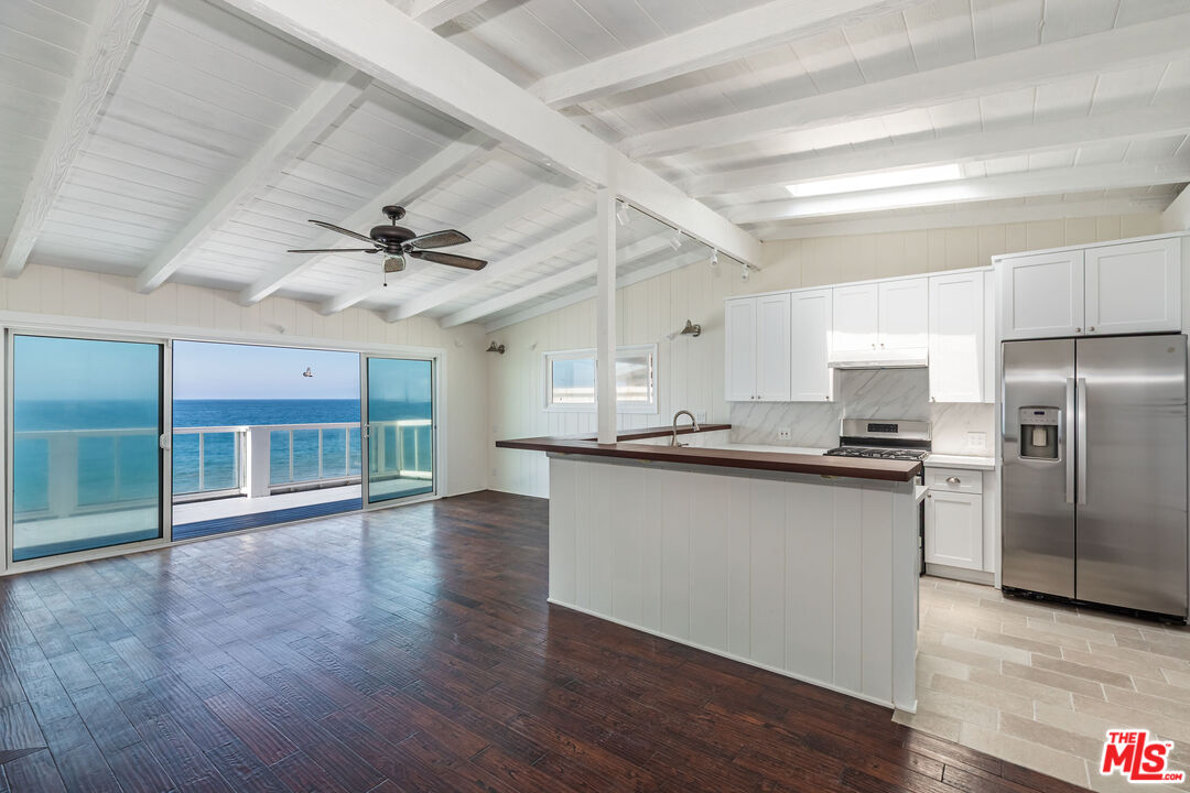a kitchen with granite countertop a stove cabinets and wooden floor