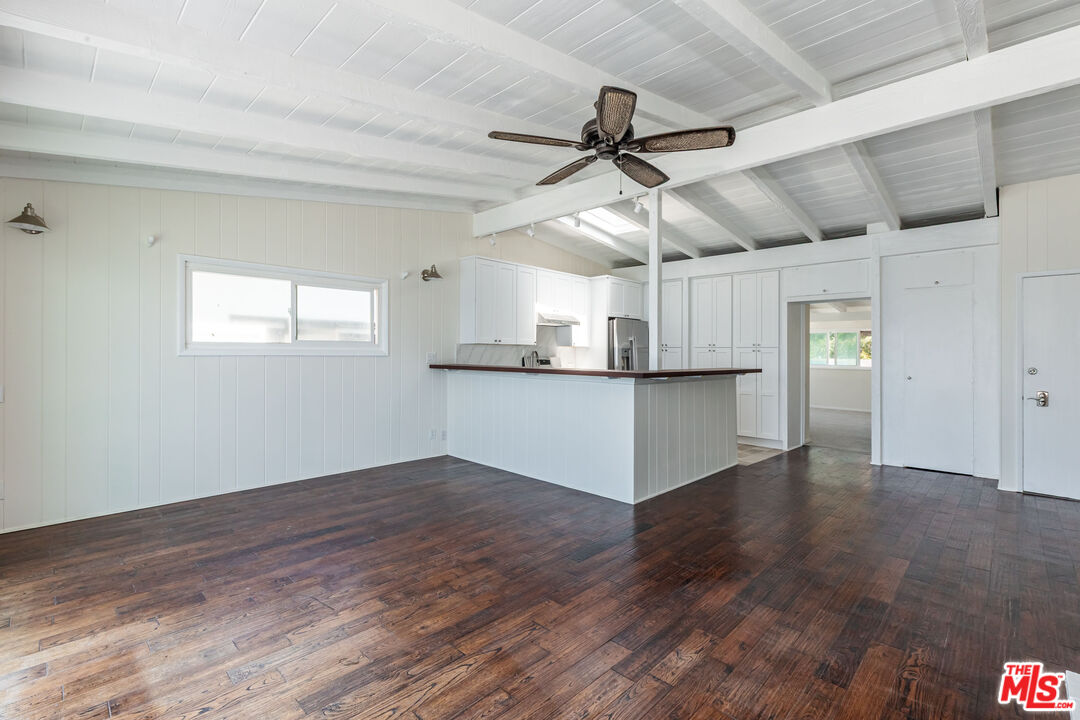 25408 Malibu Road, Unit 1/2 Malibu, CA 90265 - Photo 11 of 19 a view of a kitchen with wooden floor a ceiling fan and windows