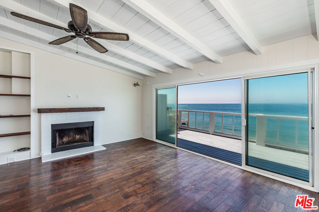 25408 Malibu Road, Unit 1/2 Malibu, CA 90265 - Photo 5 of 19 a view of an empty room with a fireplace and a window