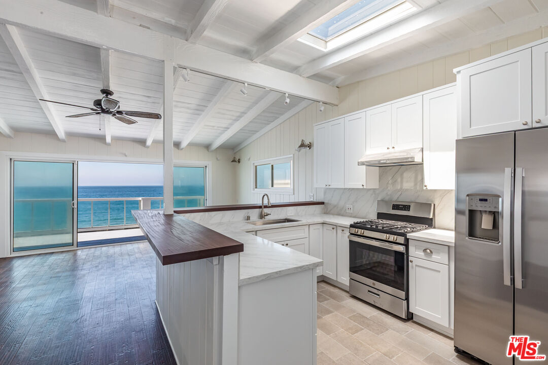 25408 Malibu Road, Unit 1/2 Malibu, CA 90265 - Photo 7 of 19 a kitchen with stainless steel appliances granite countertop a stove a sink and a refrigerator