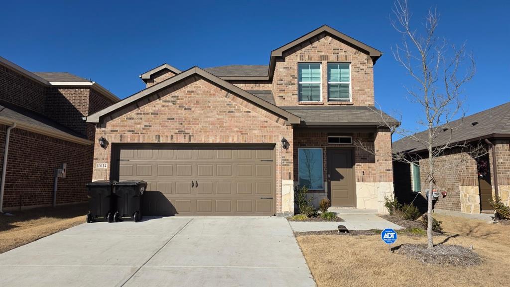 1614 Potomac Lane Blue Ridge, TX 75424 - Photo 1 of 18 Brick and stone facade residence featuring an attached two-car garage, a concrete driveway, and a front entry with an overhead light fixture