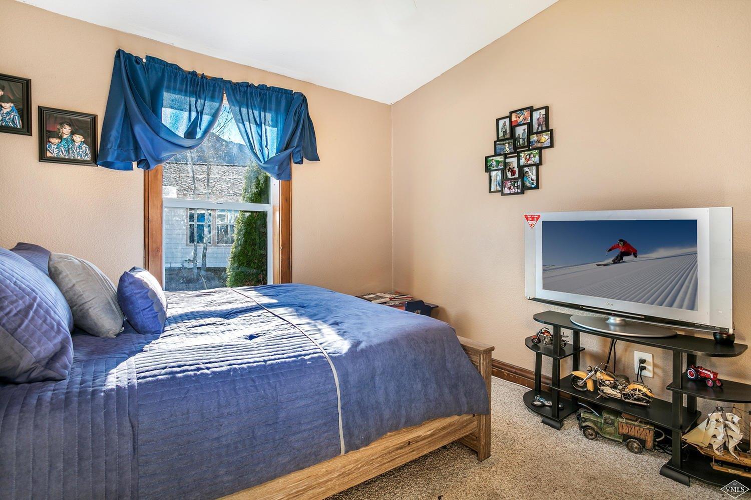 102 Cut Throat Loop Gypsum, CO 81637 - Photo 16 of 25 a bedroom with a bed and a dresser with floor to ceiling window