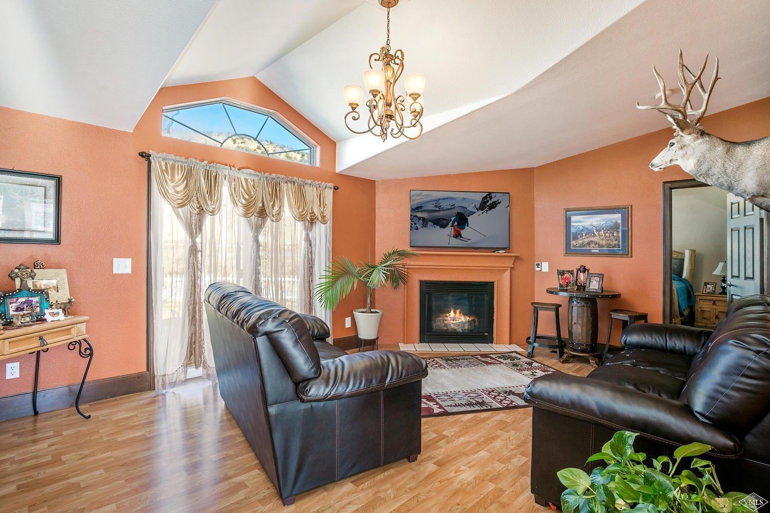 102 Cut Throat Loop Gypsum, CO 81637 - Photo 2 of 25 a living room with furniture a fireplace and a chandelier