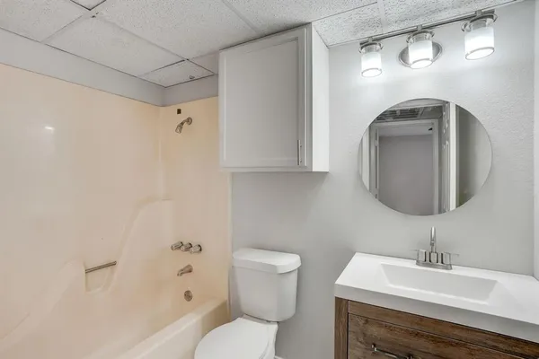 a bathroom with a toilet sink and mirror