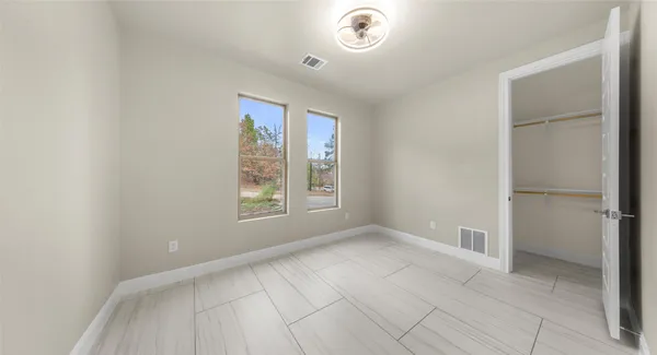an empty room with a window and ceiling fan