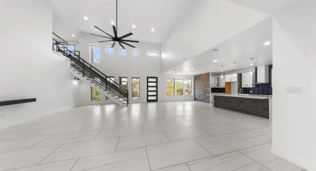 a view of an empty room and kitchen with a window