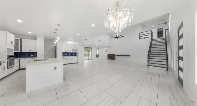 a view of a white house with a large tree