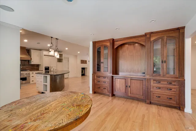 a large kitchen with stainless steel appliances granite countertop a sink a stove and a refrigerator