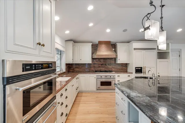 a kitchen with stainless steel appliances granite countertop a sink a stove and a microwave