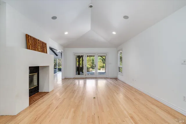 a view of a kitchen with kitchen island a sink wooden floor and a large window