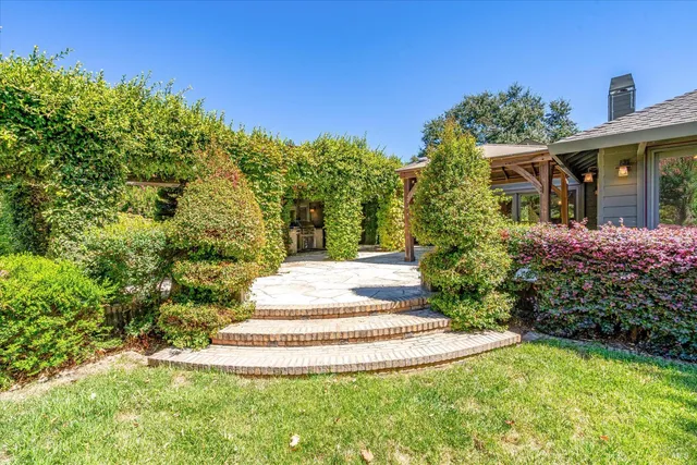 a view of a house with backyard and sitting area