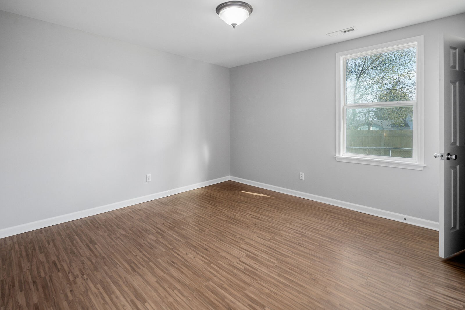 209 Manzano Road Madison, TN 37115 - Photo 7 of 15 an empty room with wooden floor and windows