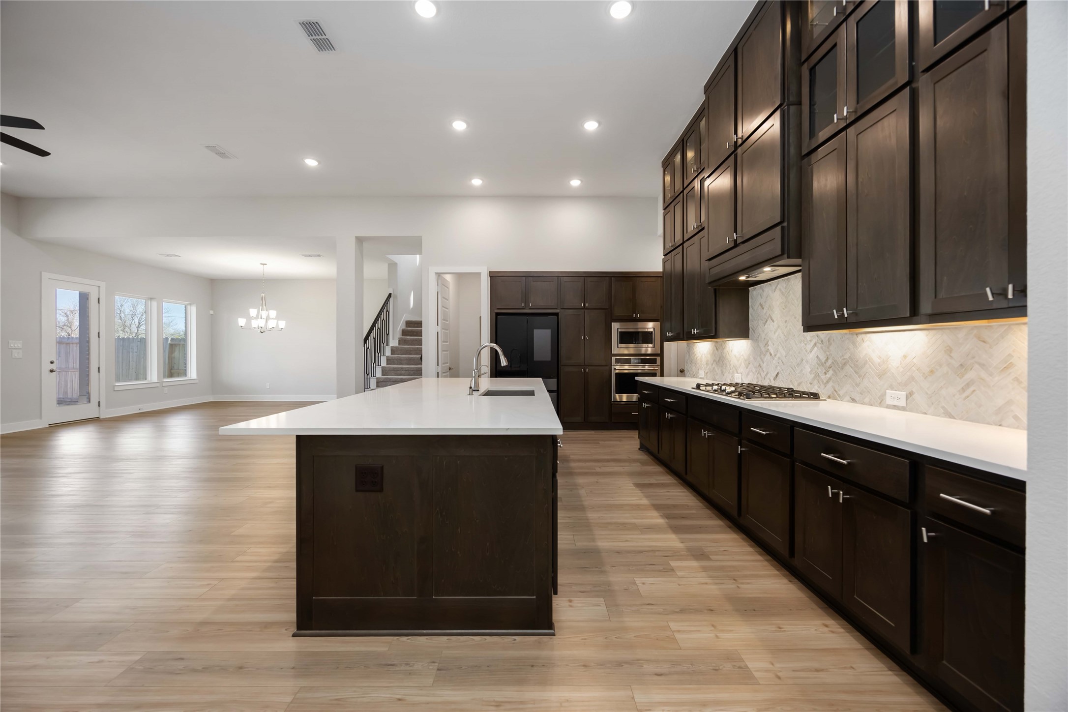 32022 Western Grv Lane Fulshear, TX 77441 - Photo 11 of 49 a kitchen with kitchen island granite countertop wooden cabinets and sink