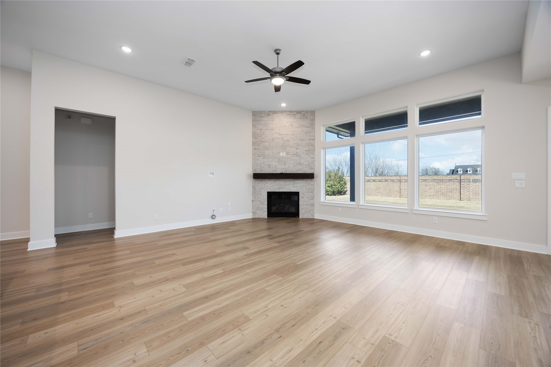32022 Western Grv Lane Fulshear, TX 77441 - Photo 16 of 49 an empty room with wooden floor a ceiling fan and windows