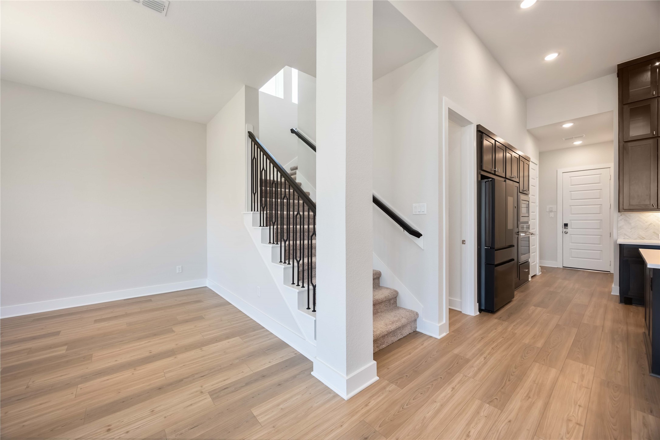 32022 Western Grv Lane Fulshear, TX 77441 - Photo 31 of 49 a view of a hallway with wooden floor and staircase