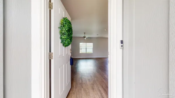 a view of a hallway with wooden floor and a window