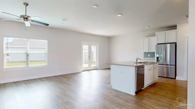 a kitchen with a refrigerator stove and wooden floor