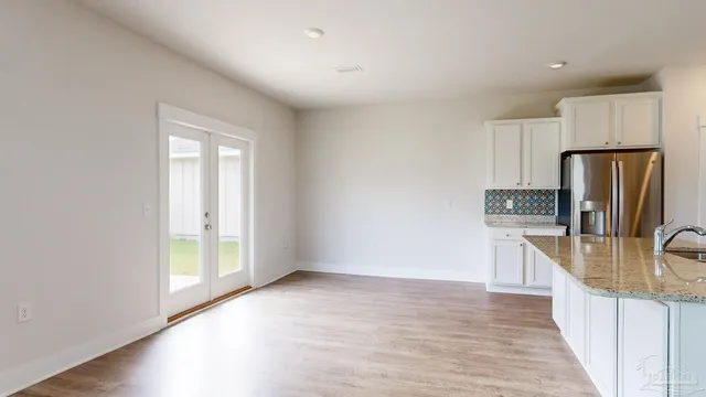 a kitchen with granite countertop a refrigerator and a sink