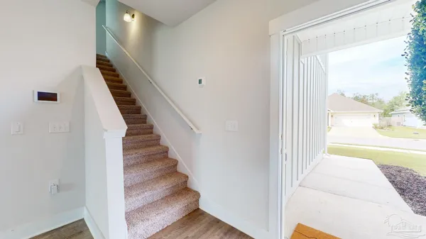 a view of a hallway with wooden floor and staircase