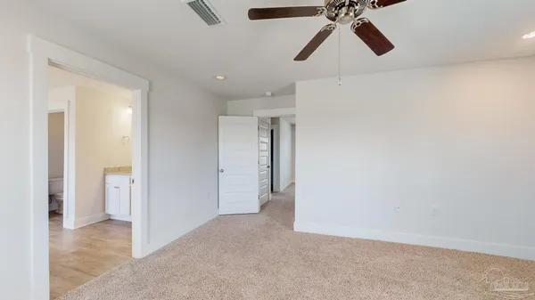 a view of an empty room and chandelier fan