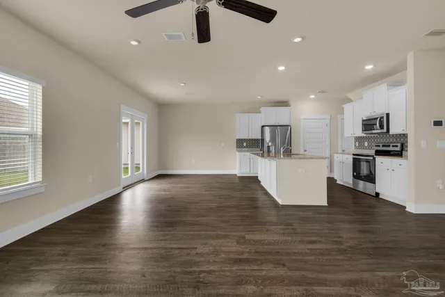 a view of kitchen with microwave a refrigerator and a stove top oven