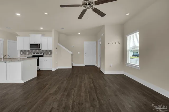 a view of empty room with wooden floor and window