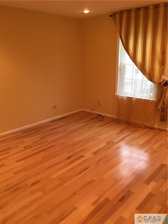 3401 Springbrook Drive Edison, NJ 08820 - Photo 12 of 21 a view of an empty room with wooden floor and a window
