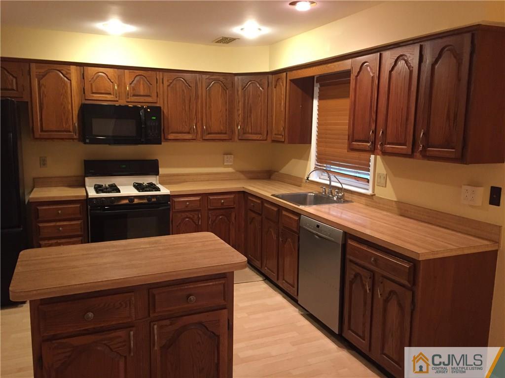 3401 Springbrook Drive Edison, NJ 08820 - Photo 5 of 21 a kitchen with wooden cabinets a sink and a stove