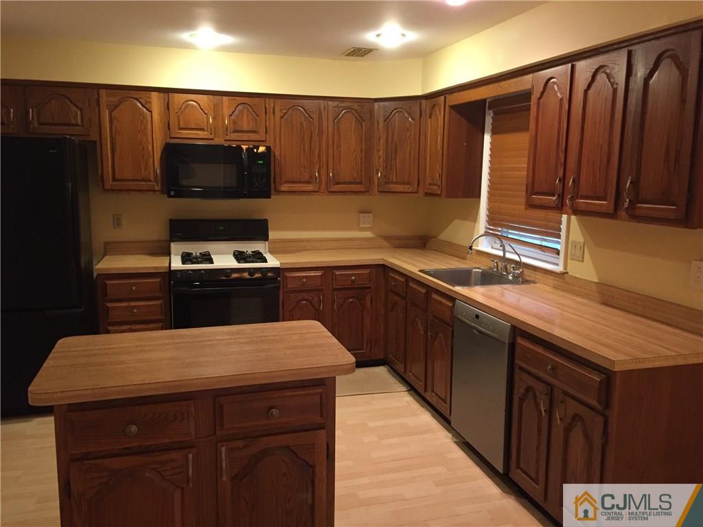 3401 Springbrook Drive Edison, NJ 08820 - Photo 6 of 21 a kitchen with wooden cabinets a sink and a stove