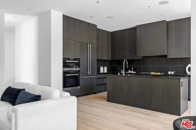 a kitchen with stainless steel appliances granite countertop a refrigerator and a stove top oven