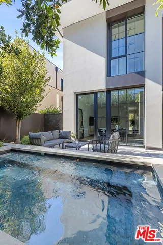 a view of house with swimming pool and outdoor seating