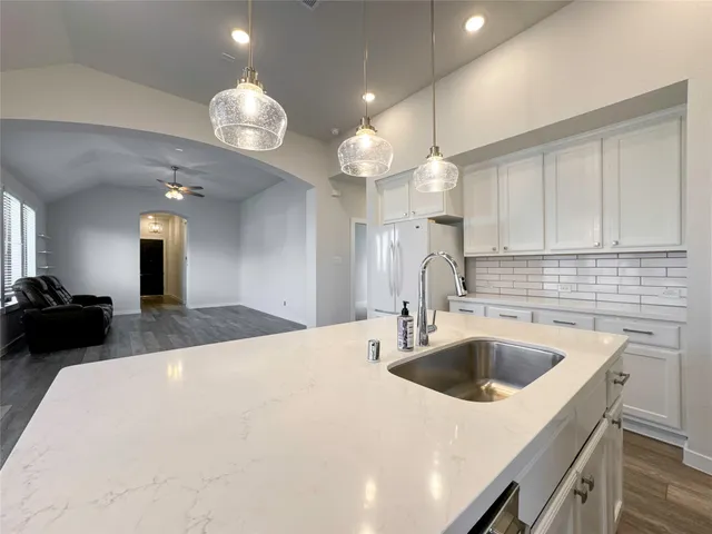 a kitchen with a sink a counter space and cabinets