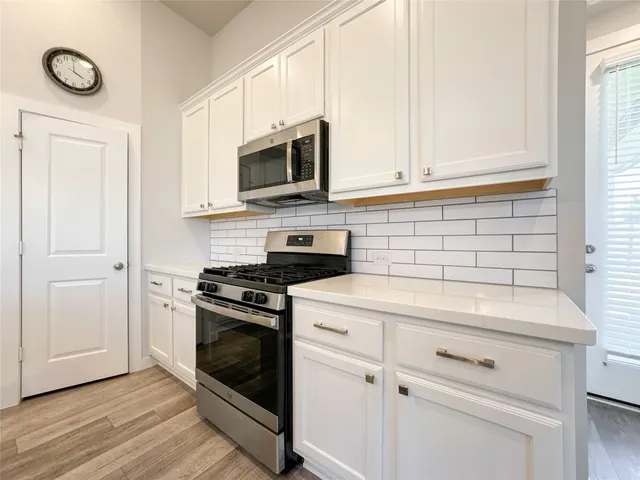 a kitchen with white cabinets and stainless steel appliances