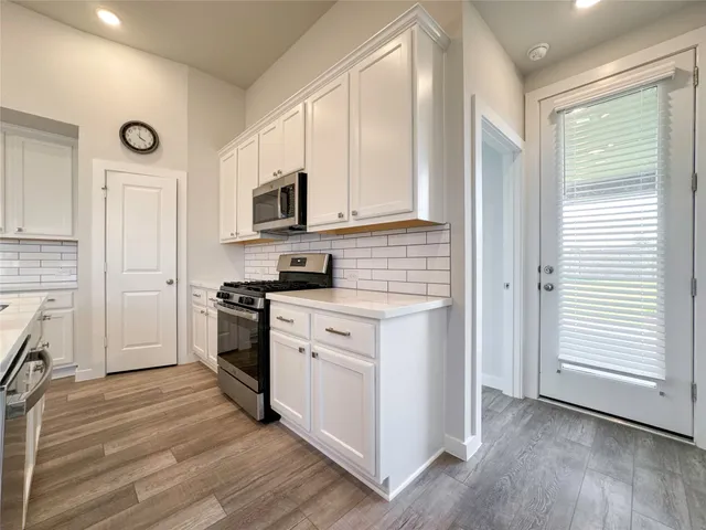 a kitchen with stainless steel appliances granite countertop a stove a sink and a refrigerator