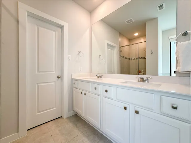 a bathroom with double vanity sinks and a mirror