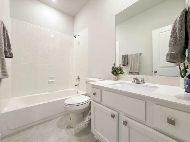 a bathroom with a sink a toilet and a large mirror
