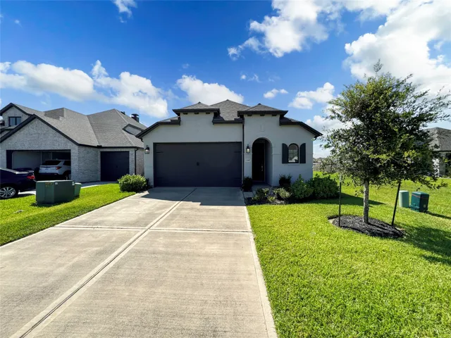 a front view of a house with a yard and trees