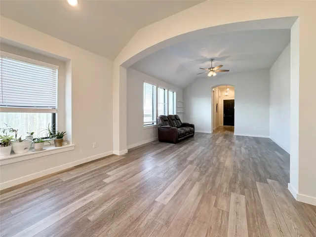 a view of a livingroom with wooden floor and windows