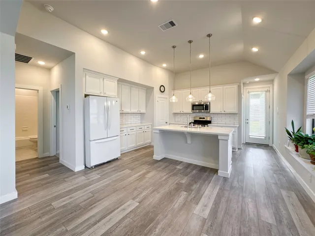 a kitchen with white cabinets and stainless steel appliances