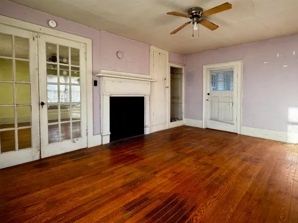 a view of empty room with wooden floor and fireplace