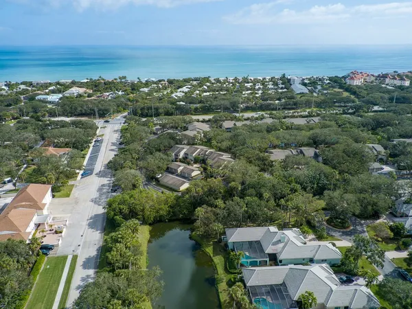 an aerial view of a city with lots of residential buildings ocean and mountain view in back