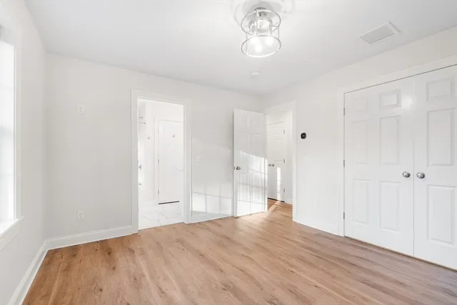 a view of empty room with wooden floor