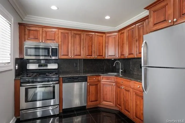 a kitchen with granite countertop stainless steel appliances and wooden cabinets
